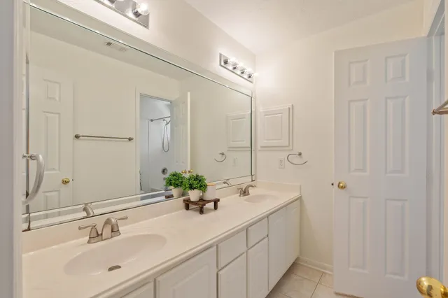 a bathroom with double vanity sinks and a mirror