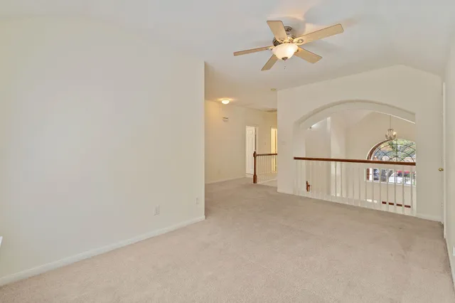 an empty room with fan and a ceiling fan with a window