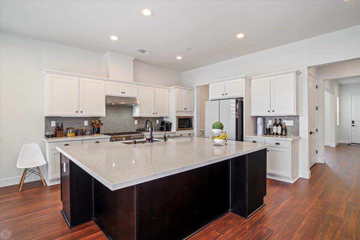 4205 Maddy Avenue Tracy, CA 95377 - Photo 9 of 45 a kitchen with a sink a stove a refrigerator and white cabinets