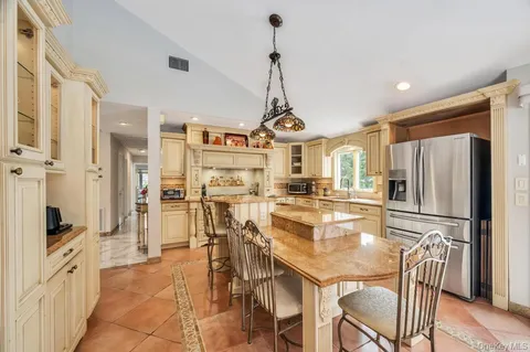 a kitchen with stainless steel appliances granite countertop a refrigerator a oven a sink a stove and white cabinets