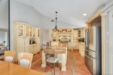 a living room with furniture a large window and stainless steel appliances