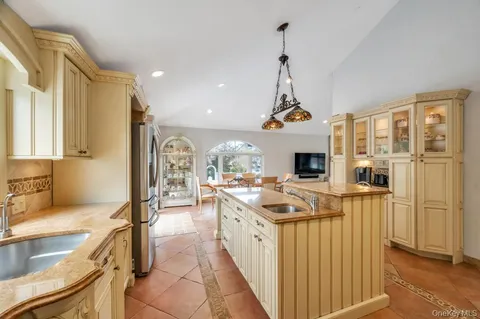a kitchen with stainless steel appliances granite countertop a stove and a view of living room