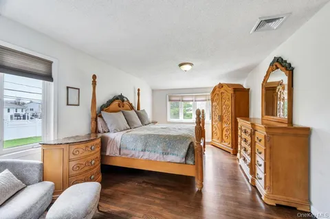 a bedroom with bed and wooden floor