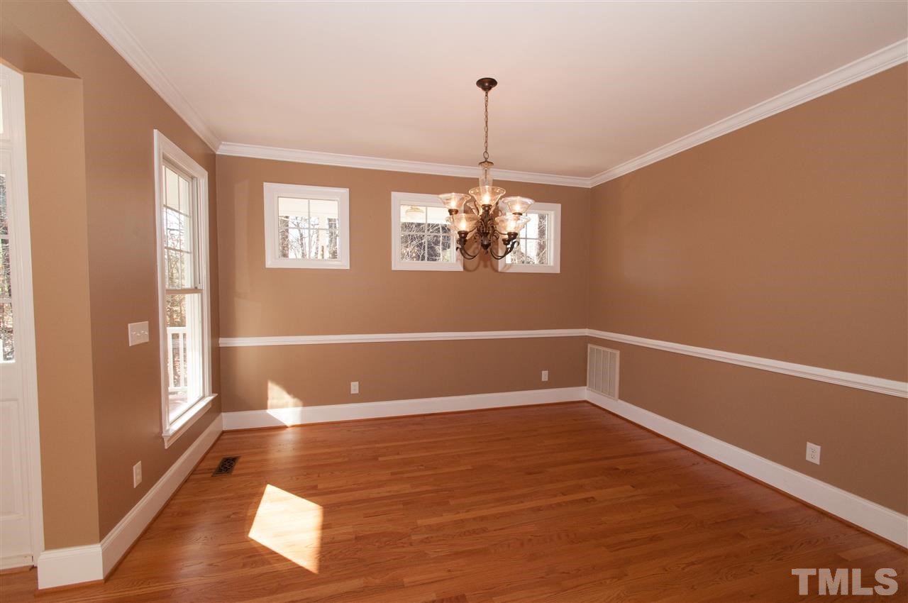 13423 Melvin Arnold Road Raleigh, NC 27613 - Photo 5 of 25 Spacious formal room with lovely chandelier and hardwood floors