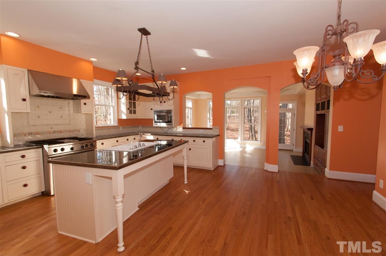 13423 Melvin Arnold Road Raleigh, NC 27613 - Photo 8 of 25 Large island/bar, granite counter top, fabulous stainless steel gas stove with grill, plenty of cabinets and a walk in pantry