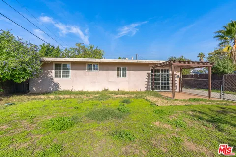 a view of a house with backyard and sitting area