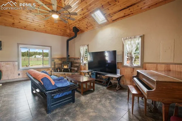 a living room with furniture a flat screen tv and a large window