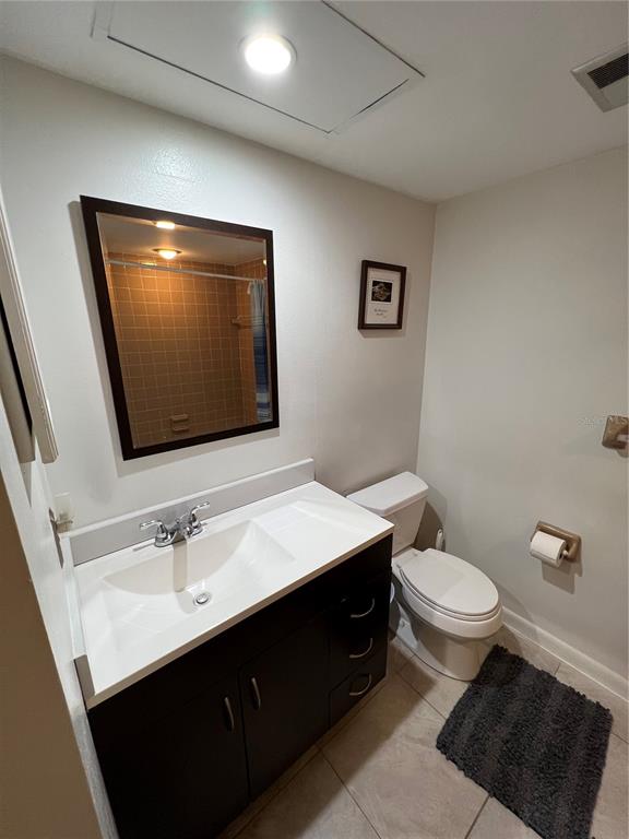 7110 Cognac Drive, Unit 2 New Port Richey, FL 34653 - Photo 12 of 24 a bathroom with a toilet sink and mirror