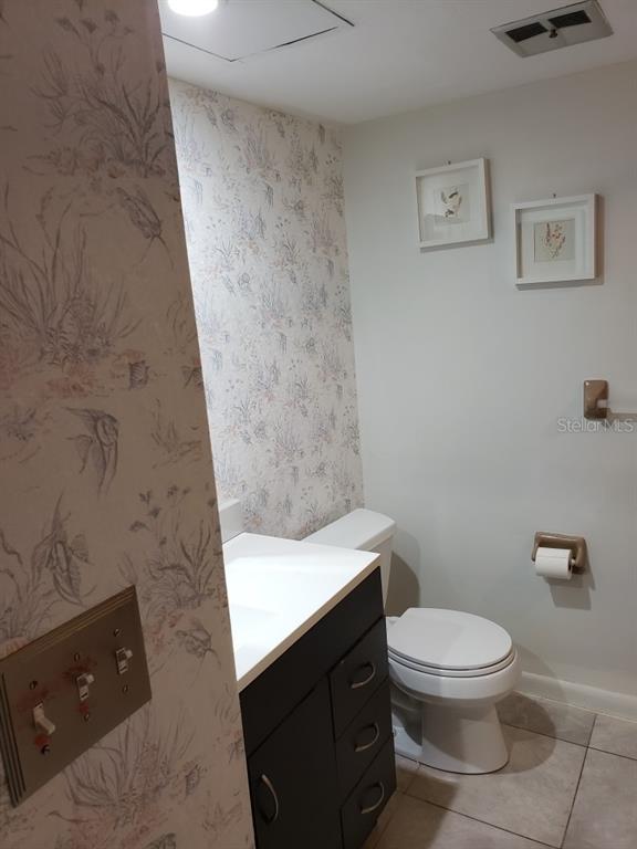 7110 Cognac Drive, Unit 2 New Port Richey, FL 34653 - Photo 23 of 24 a bathroom with a toilet a sink and mirror