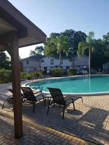 a view of a swimming pool with lounge chairs in patio