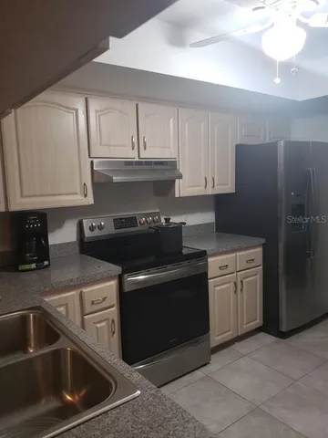 a kitchen with granite countertop a stove sink and cabinets