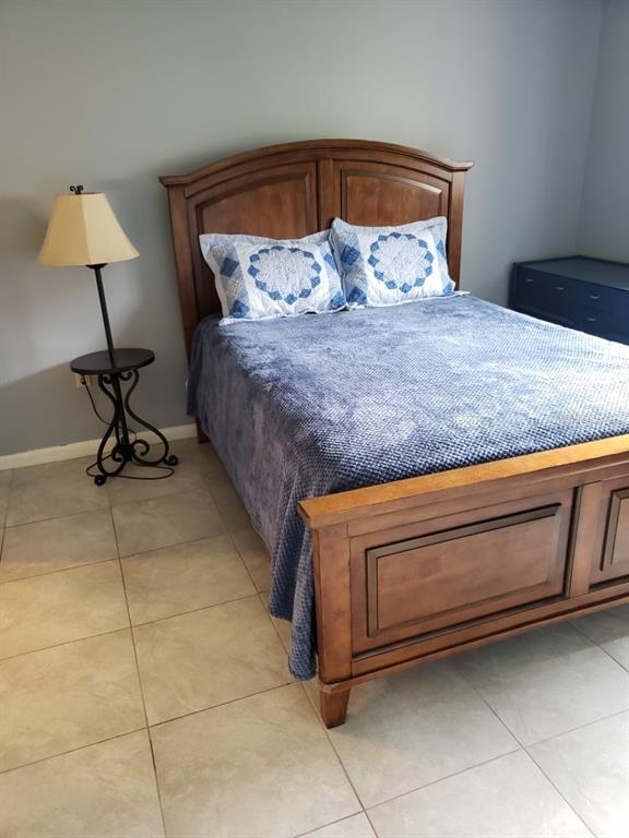 7110 Cognac Drive, Unit 2 New Port Richey, FL 34653 - Photo 10 of 24 a bedroom with a bed and a lamp