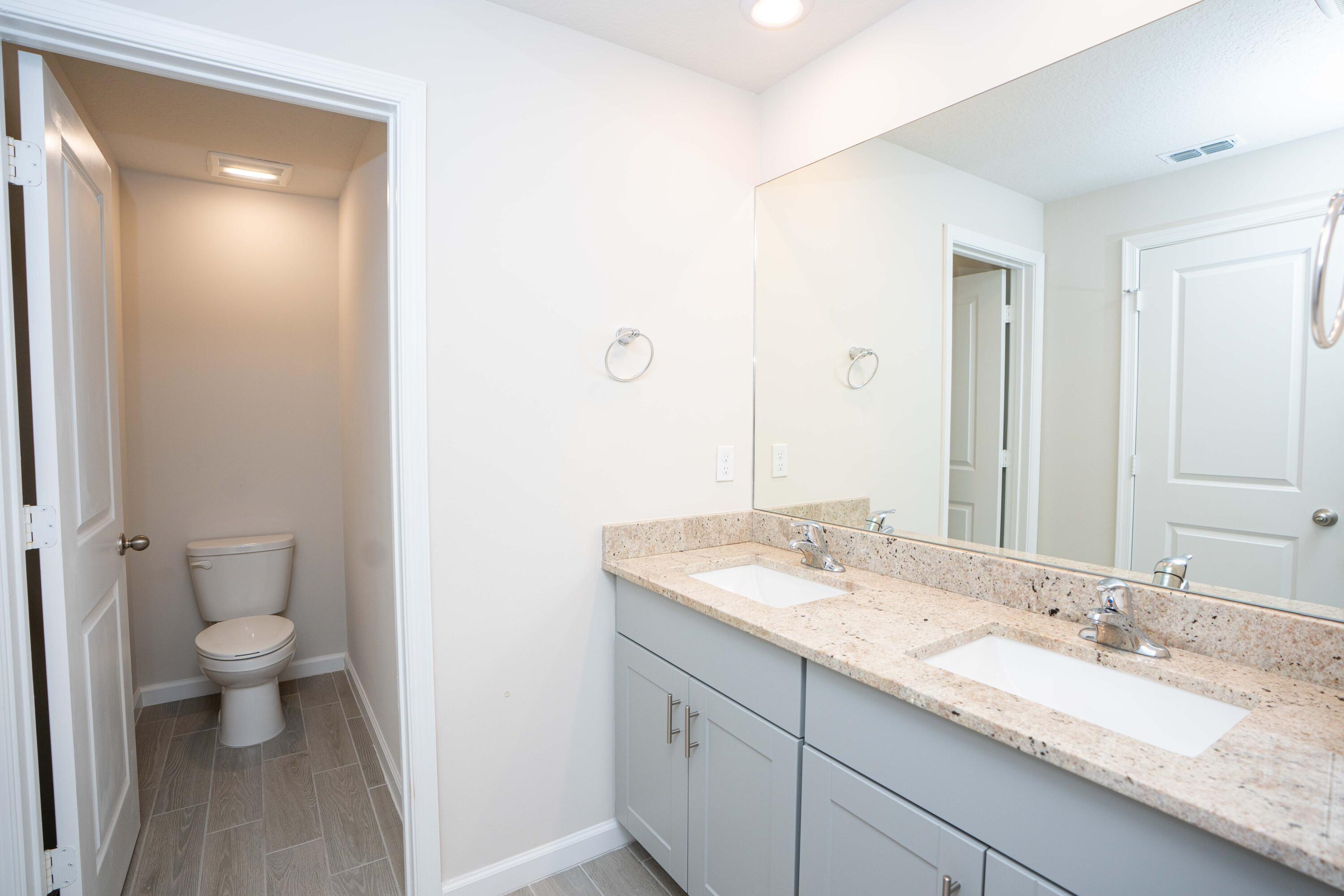 197 Osprey Preserve Boulevard Stuart, FL 34994 - Photo 12 of 26 a bathroom with a granite countertop sink and a mirror