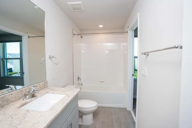 a bathroom with a granite countertop sink toilet and shower