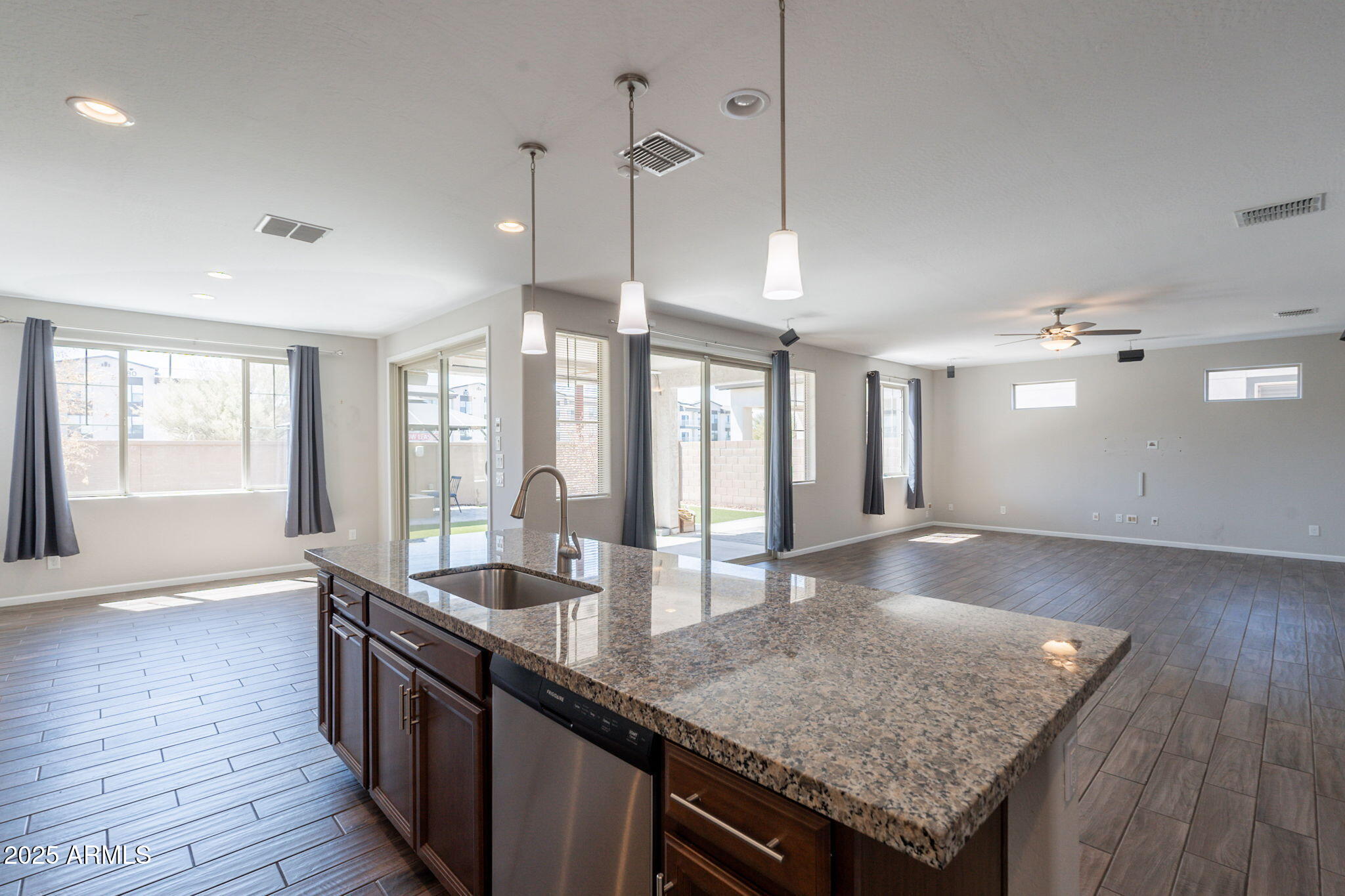 98 North Bay Drive Gilbert, AZ 85233 - Photo 8 of 37 a kitchen with granite countertop kitchen island a sink appliances and wooden floor