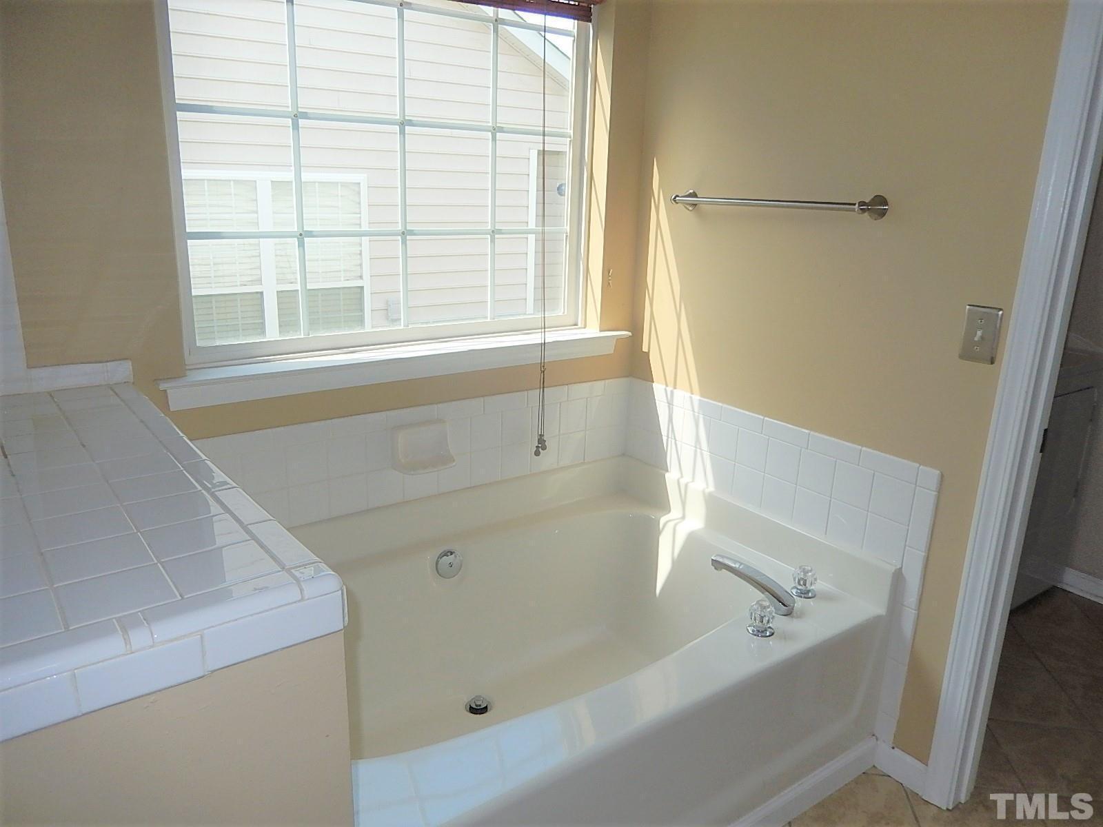 4717 Delta Ridge Court Raleigh, NC 27612 - Photo 15 of 30 a bathroom with a bathtub and window