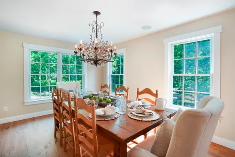 a dining room with furniture a chandelier and wooden floor