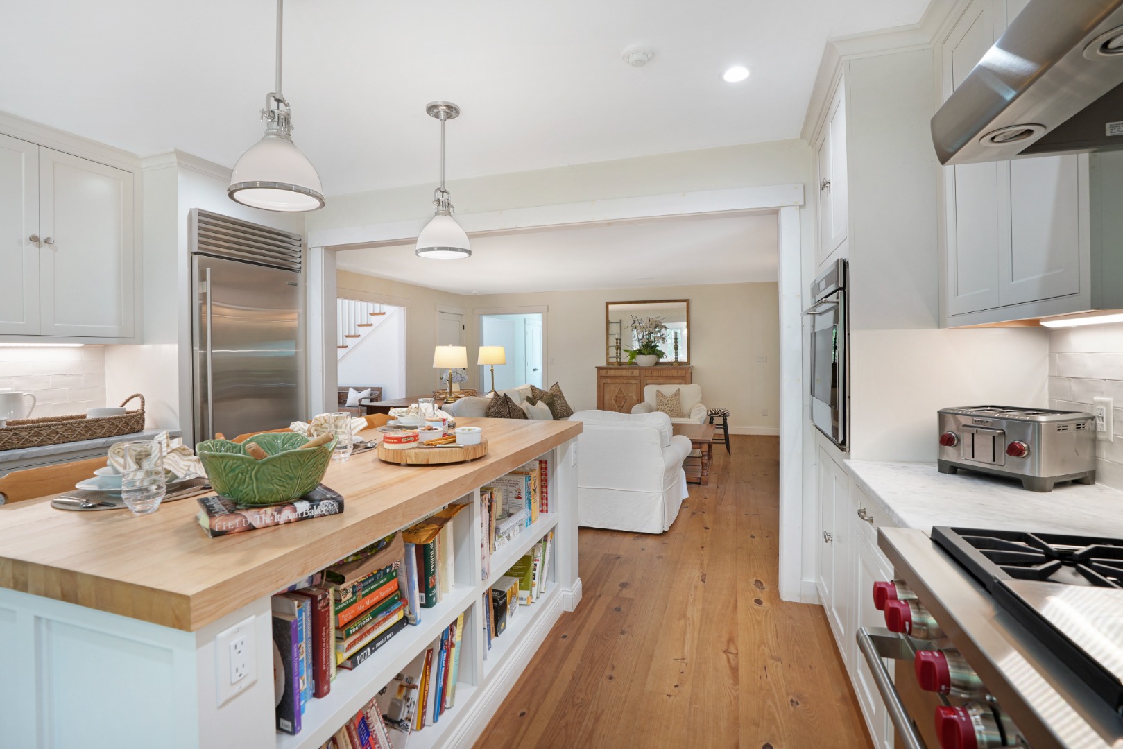 53 Stoney Hill Road West Tisbury, MA 02568 - Photo 12 of 51 a large kitchen with kitchen island a stove a sink a refrigerator and a dining table with wooden floor