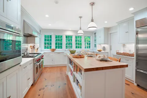 a kitchen with kitchen island a counter space a sink appliances and a large window
