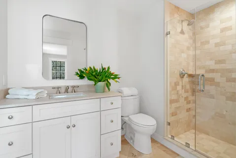 a bathroom with a granite countertop sink a toilet and a mirror