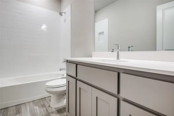 a bathroom with a sink toilet vanity and tub