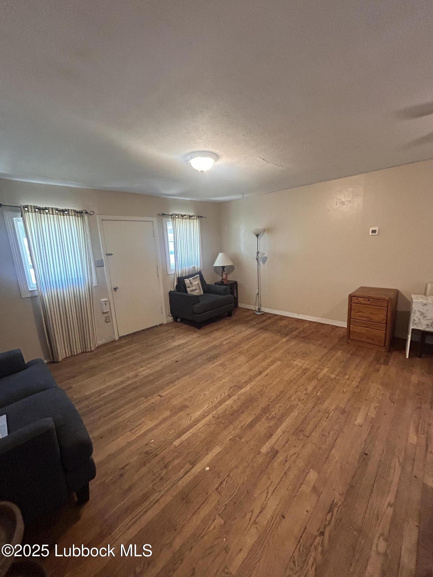 2712 37th Street Lubbock, TX 79413 - Photo 3 of 12 a spacious bedroom with a bed and a dresser