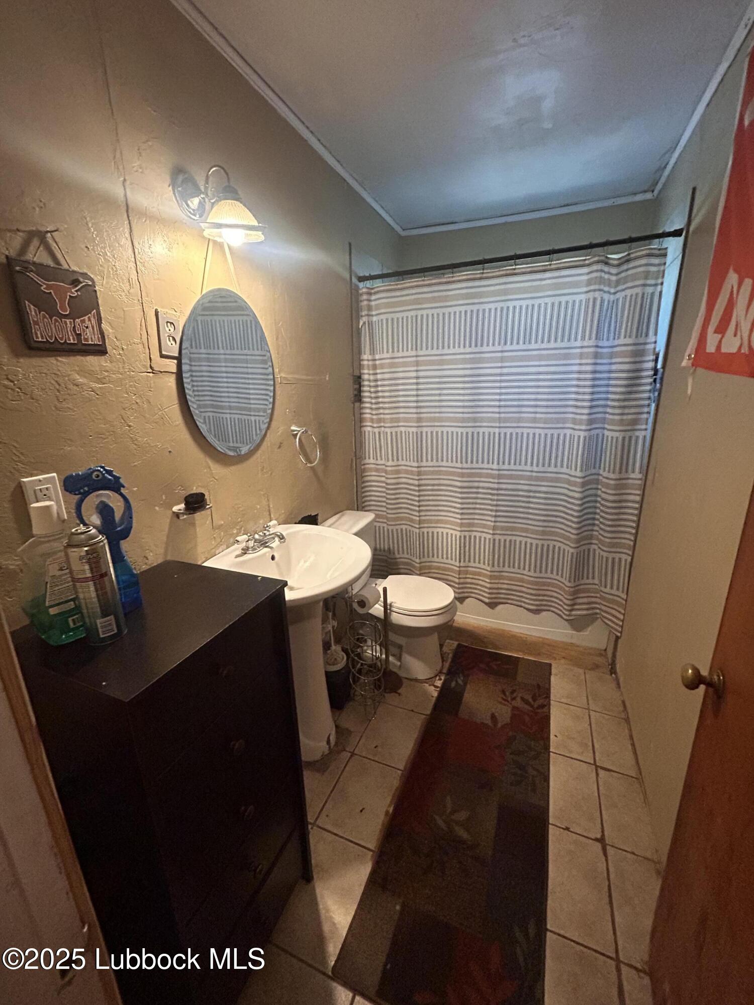 2712 37th Street Lubbock, TX 79413 - Photo 9 of 12 a bathroom with a sink a toilet and shower