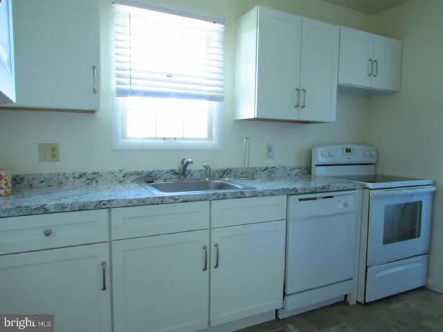 a bathroom with cabinets appliances and a window
