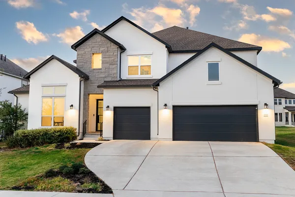 a front view of house with yard and garage