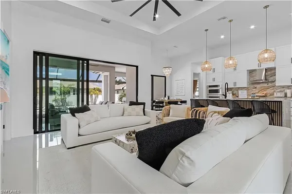 a living room with furniture a large window and chandelier