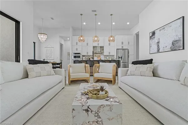 a living room with furniture kitchen view and a table