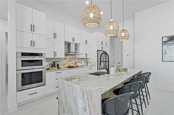 a kitchen with granite countertop a sink cabinets and stainless steel appliances