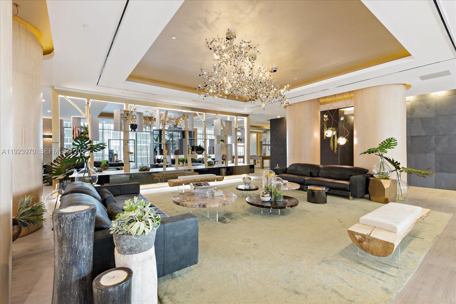 488 Northeast 18th Street, Unit 4102 Miami, FL 33132 - Photo 26 of 60 a living room with furniture a chandelier and a large mirror