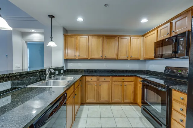 a kitchen with a sink a counter top space cabinets and stainless steel appliances