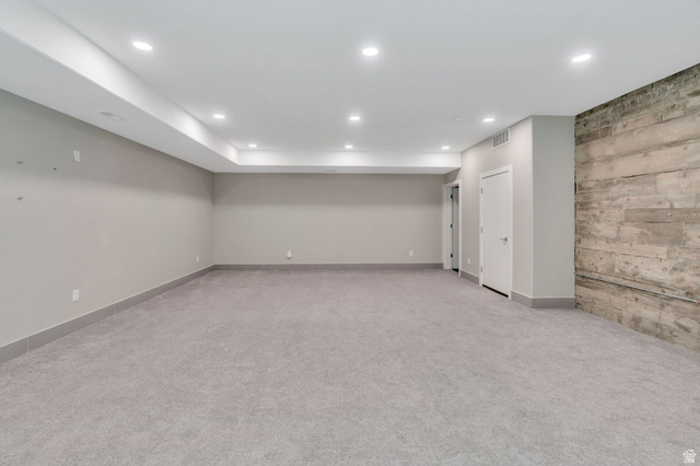 7045 South 300 East Midvale, UT 84047 - Photo 32 of 49 Spacious interior featuring light gray carpeting, recessed lighting, a unique concrete-textured accent wall, and neutral wall paint