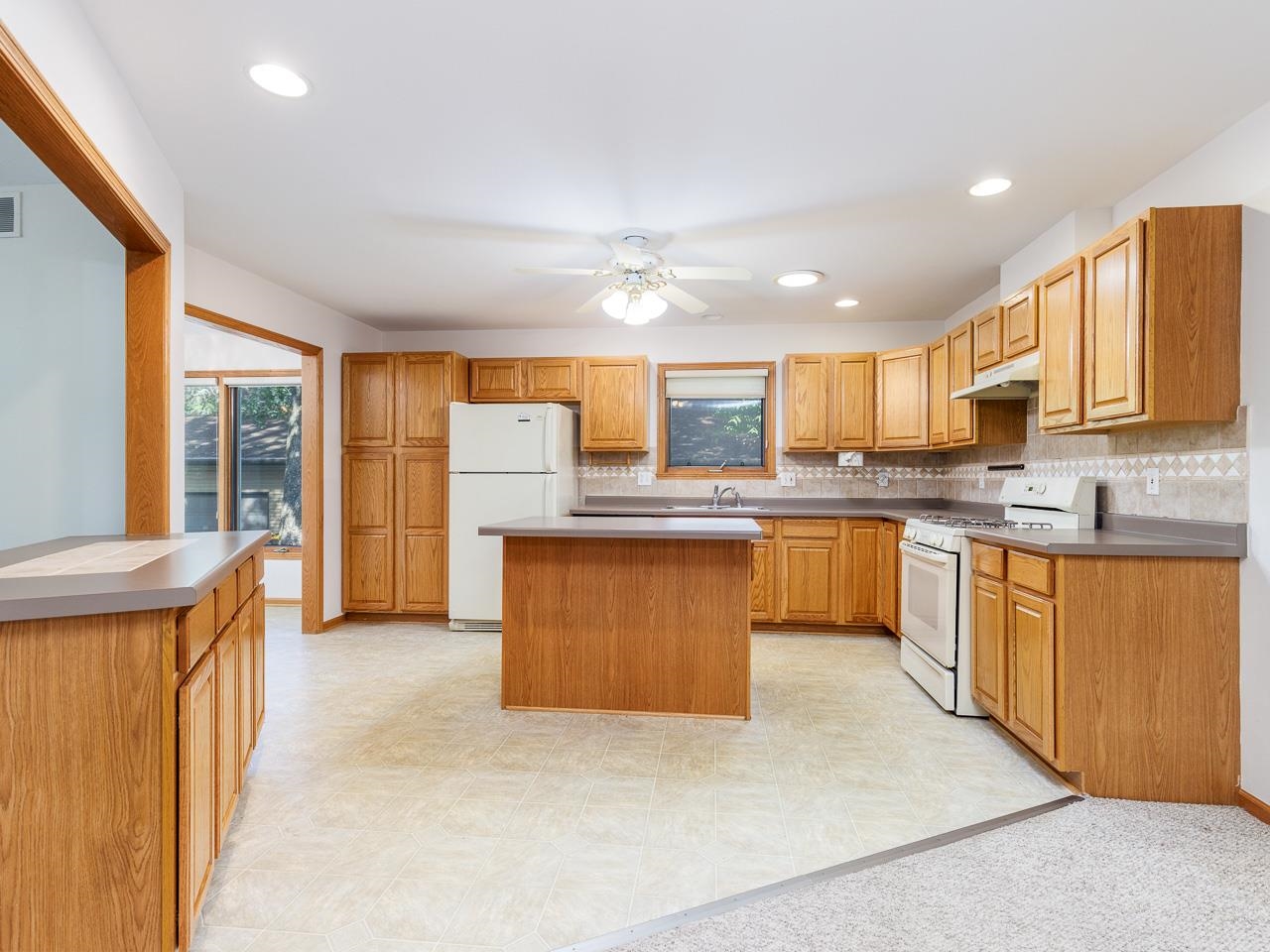 2085 Lake Summerset Road Lake Summerset, IL 61019 - Photo 9 of 32 a large kitchen with kitchen island a sink a stove a refrigerator cabinets and a large window