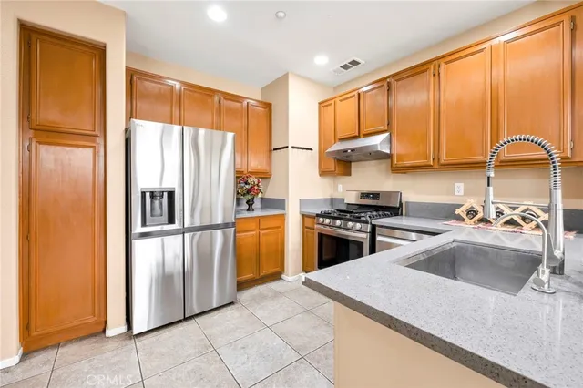 a kitchen with a refrigerator a sink and cabinets