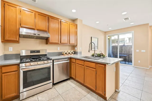 a kitchen with stainless steel appliances granite countertop a stove a sink and a microwave