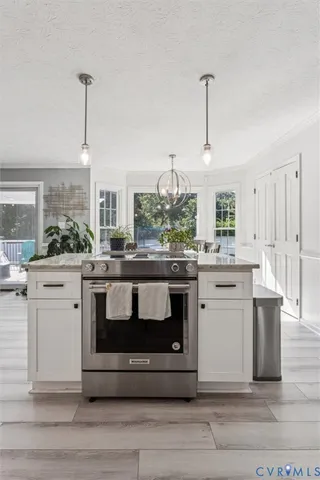 a kitchen with stainless steel appliances kitchen island granite countertop a stove a sink and a wooden floors