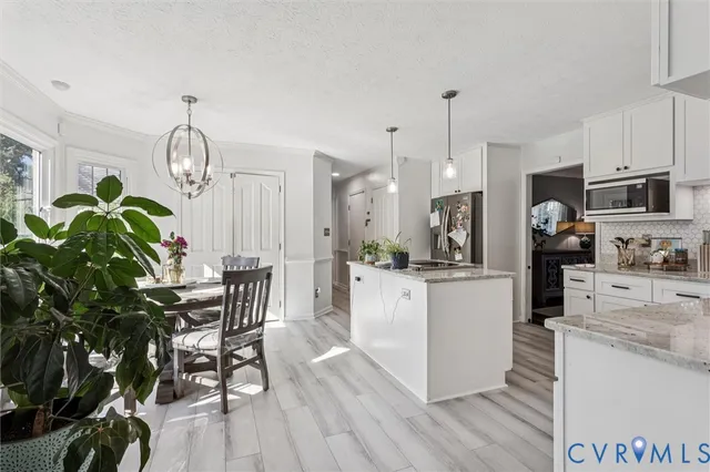 a kitchen with sink a refrigerator and chairs