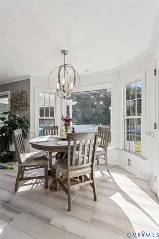 a view of a dining room with furniture a chandelier and wooden floor