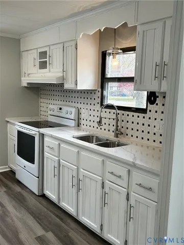 a kitchen with white cabinets a sink and dishwasher with wooden floor