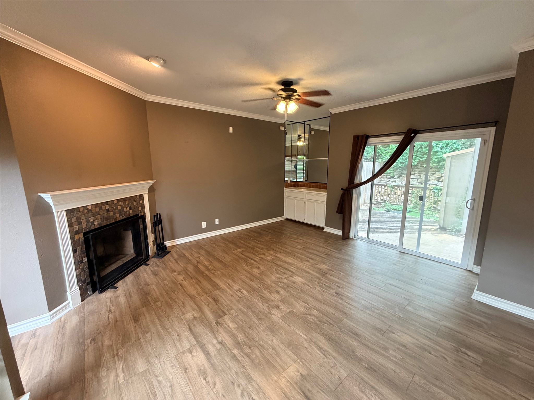 6600 Valleyside Road, Unit D20 Austin, TX 78731 - Photo 6 of 14 A spacious living area showcasing a cozy fireplace, built-in dry bar, and easy access to outdoor living.