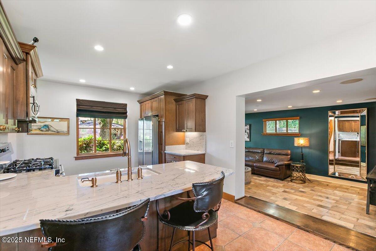 701 Old Hickory Road Jacksonville, FL 32207 - Photo 16 of 36 a dining hall with stainless steel appliances kitchen island granite countertop a dining table and chairs with wooden floor