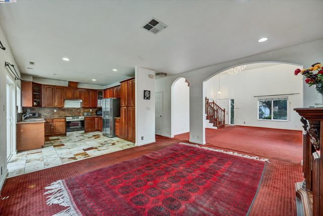 a large kitchen with kitchen island granite countertop a refrigerator and a sink