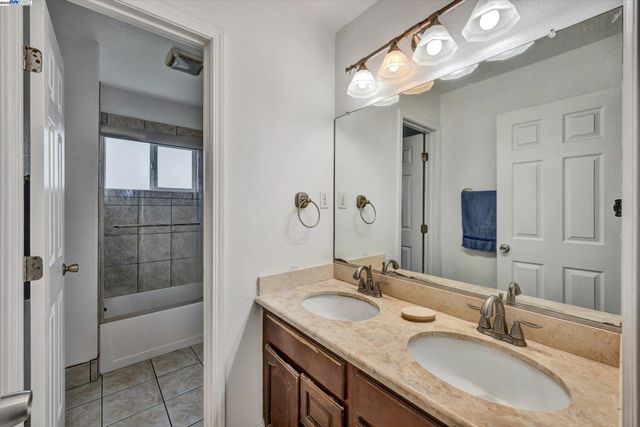 a bathroom with double vanity and a mirror