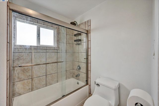 a bathroom with a bathtub shower and toilet