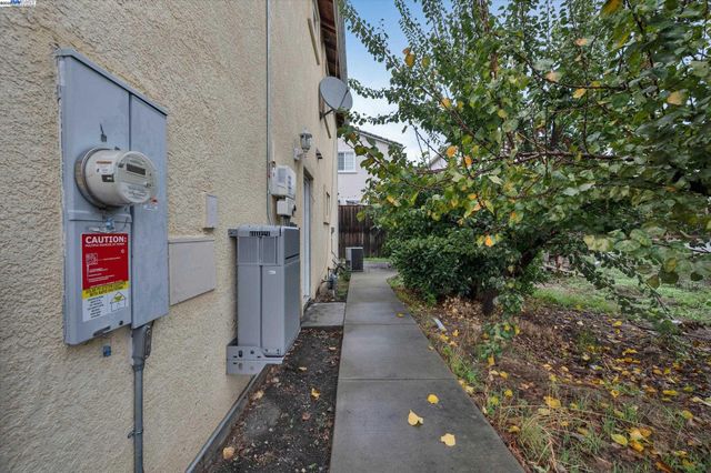 a pathway of a house with a yard and wooden fence