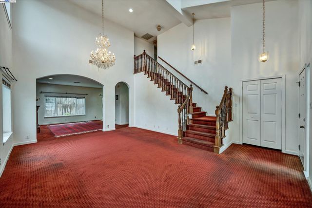 a view of empty room with a fireplace and chandelier