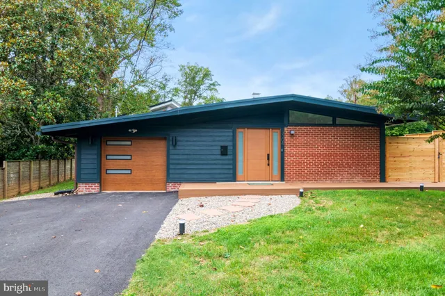 a front view of house with yard and trees in the background